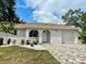 Charming home exterior featuring a well-manicured front yard, fresh landscaping, and brick paved driveway at 11241 Temple Ct, Seminole, FL 33772