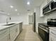 Contemporary kitchen featuring stainless steel appliances, white cabinets, a large island, and modern finishes for cooking at 11241 Temple Ct, Seminole, FL 33772