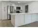Modern kitchen with white cabinets, stainless steel appliances, a stylish tile backsplash, and a spacious countertop island at 11241 Temple Ct, Seminole, FL 33772