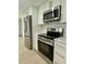 Modern kitchen equipped with stainless steel appliances, stylish backsplash, and white cabinets, for a seamless cooking experience at 11241 Temple Ct, Seminole, FL 33772