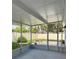 The screened lanai overlooks the backyard featuring a brick paver patio and stone firepit at 11241 Temple Ct, Seminole, FL 33772