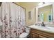 Bathroom featuring a floral shower curtain, decorative mirror, and vanity at 11862 Frost Aster Dr, Riverview, FL 33579