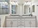 Elegant bathroom featuring double vanity, granite countertops, and stylish mirrors at 11862 Frost Aster Dr, Riverview, FL 33579