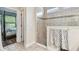 Bathroom with tiled shower, decorative border and a view into bedroom at 11862 Frost Aster Dr, Riverview, FL 33579