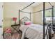 Inviting bedroom with a four-poster bed, black nightstand and neutral decor at 11862 Frost Aster Dr, Riverview, FL 33579