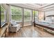 Bedroom with wood floors, natural light, and a comfortable seating area with a beautiful outside view at 11862 Frost Aster Dr, Riverview, FL 33579