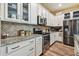 Modern kitchen with stainless appliances, granite counters, tile backsplash, and white cabinetry at 11862 Frost Aster Dr, Riverview, FL 33579