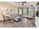 Bright living room showcasing wood floors, natural light, comfortable seating, and a stylish ottoman at 11862 Frost Aster Dr, Riverview, FL 33579