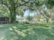 Lush backyard featuring a covered patio, a charming pergola, mature trees, and ample green space at 13116 N Oregon Ave, Tampa, FL 33612