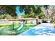 Charming single-story home with lush green lawn, mature trees, brick accents, and an attached carport at 13116 N Oregon Ave, Tampa, FL 33612
