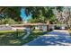Charming single-story home featuring a brick chimney and a long driveway with mature tree coverage at 13116 N Oregon Ave, Tampa, FL 33612