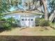 Exterior view of the detached garage surrounded by lush landscaping at 13116 N Oregon Ave, Tampa, FL 33612