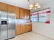 Bright eat-in kitchen area features stainless steel refrigerator, tile floors, and oak cabinets at 13116 N Oregon Ave, Tampa, FL 33612