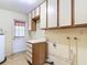 Functional laundry room with ample cabinet space and laminate floors at 13116 N Oregon Ave, Tampa, FL 33612