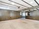 Large living room featuring wood paneling, vintage bar area, and neutral carpet at 13116 N Oregon Ave, Tampa, FL 33612