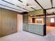 Inviting living room features wood paneling, a vintage bar area, and neutral carpet at 13116 N Oregon Ave, Tampa, FL 33612