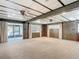 Spacious living room with wood paneling, soft carpet, large windows, and sliding glass doors to the porch at 13116 N Oregon Ave, Tampa, FL 33612