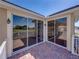 Corner of brick balcony with sliding glass doors, offering serene golf course views at 13143 Palmilla Cir, Dade City, FL 33525