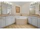 Bathroom showcases a soaking tub with granite tile surround and dual vanities with granite countertops at 13143 Palmilla Cir, Dade City, FL 33525