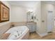 Bathroom featuring a soaking tub with tile surround and vanity with granite countertop at 13143 Palmilla Cir, Dade City, FL 33525
