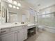 Well-lit bathroom features a large vanity, shower/tub combo, and neutral tile flooring at 13143 Palmilla Cir, Dade City, FL 33525
