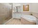Bathroom featuring a glass shower, soaking tub, vanity with granite countertop, and light wood-look flooring at 13143 Palmilla Cir, Dade City, FL 33525