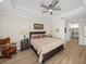 Bright bedroom featuring a tray ceiling, ceiling fan, and ensuite bathroom at 13143 Palmilla Cir, Dade City, FL 33525