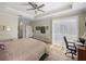 Cozy bedroom with ceiling fan, access to the patio, and an ensuite bathroom at 13143 Palmilla Cir, Dade City, FL 33525
