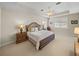Spacious bedroom featuring a tray ceiling, plush carpeting, and plantation shutters for a serene ambiance at 13143 Palmilla Cir, Dade City, FL 33525