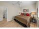 Bedroom featuring a bed with patterned bedding, wood-look flooring, ceiling fan, and doorway to bathroom at 13143 Palmilla Cir, Dade City, FL 33525