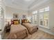 Bedroom features twin beds with neutral bedding, wood-look flooring, and shuttered windows at 13143 Palmilla Cir, Dade City, FL 33525