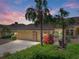 Charming single-story home featuring lush landscaping, a three-car garage, and a tiled roof at 13143 Palmilla Cir, Dade City, FL 33525