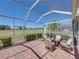Screened lanai with brick pavers and seating overlooks a lush green landscape at 13143 Palmilla Cir, Dade City, FL 33525
