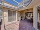 Covered patio area with grill, dining table, ceiling fan, and access to the house at 13143 Palmilla Cir, Dade City, FL 33525