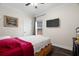 Bedroom featuring a TV, a window, a bed with red pillows, and wood-look floors at 1410 25Th N St, St Petersburg, FL 33713