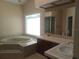 Bright bathroom featuring a soaking tub, double vanity, and separate shower at 14115 Harborwood Dr, Largo, FL 33774