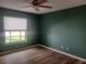 Bedroom with green walls, window, and wood floors at 14115 Harborwood Dr, Largo, FL 33774