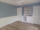 Bedroom with blue walls, a ceiling fan, wood floors, built-in shelving and closet at 14115 Harborwood Dr, Largo, FL 33774