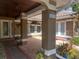 Inviting home entrance with a covered porch, decorative plants, and clear view through the glass door at 14115 Harborwood Dr, Largo, FL 33774