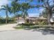 Charming single-story home with a well-manicured lawn, tropical landscaping, and a tile roof at 14115 Harborwood Dr, Largo, FL 33774