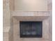 Close-up of a tile fireplace with a black screen in a living room at 14115 Harborwood Dr, Largo, FL 33774