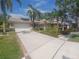 Beautiful single Gathering home with lush landscaping, palm trees, a three-car garage and a tile roof at 14115 Harborwood Dr, Largo, FL 33774