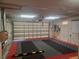 Spacious three-car garage featuring black and red interlocking floor tiles, offering a clean and organized space at 14115 Harborwood Dr, Largo, FL 33774