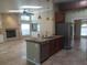 Open-concept kitchen with granite countertops, stainless steel appliances, and a view of the fireplace at 14115 Harborwood Dr, Largo, FL 33774
