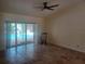 Open living room with travertine floors, a ceiling fan, and sliding doors to the pool area at 14115 Harborwood Dr, Largo, FL 33774