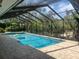 Sparkling pool with screened enclosure, and lush tropical landscaping at 14115 Harborwood Dr, Largo, FL 33774
