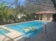Inviting swimming pool with spa, screened enclosure, and tropical landscaping at 14115 Harborwood Dr, Largo, FL 33774