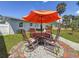 Outdoor patio area with a table, chairs, and orange umbrella, perfect for relaxing and entertaining at 1734 Shore Acres Ne Blvd, St Petersburg, FL 33703