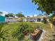 Lush backyard featuring a garden, patio with seating, privacy fence, and mature trees at 1734 Shore Acres Ne Blvd, St Petersburg, FL 33703