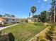 Well-manicured backyard with a stone pathway, and lush greenery, under a blue sky at 1734 Shore Acres Ne Blvd, St Petersburg, FL 33703